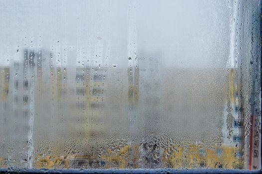 View of city houses through a fogged window close-up