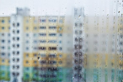 View of city houses through a fogged window close-up