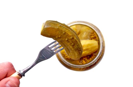 pickled cucumber on a fork on white on a jar background isolated