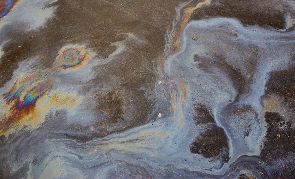 Abstract background with oil stain of oil products.Oil stain on Asphalt, color Gasoline fuel spots on Asphalt Road as Texture or Background.