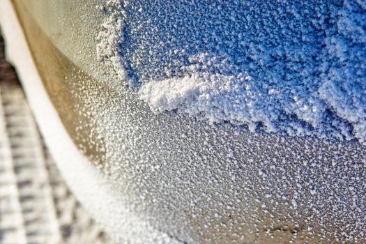 snow texture on the bumper of the car. Selective focus