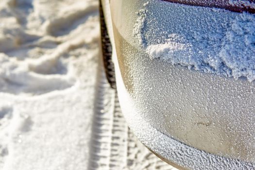 snow texture on the bumper of the car. Selective focus