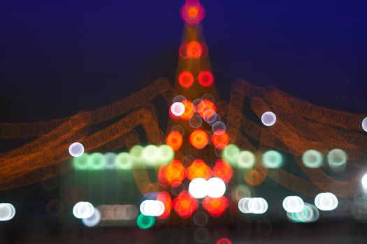 Abstract christmas background with christmas tree with decorations, defocused bokeh lights outdoors. Beautiful sparkling backdrop, texture.