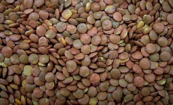 Heap of brown lentil texture as background. Top view.