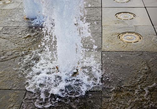 Water splashes in the city fountain close up in defocus.Selective focus