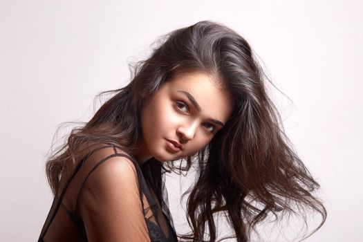 Portrait of sexy woman with beautiful make-up and long curly hair. Girl looking at camera