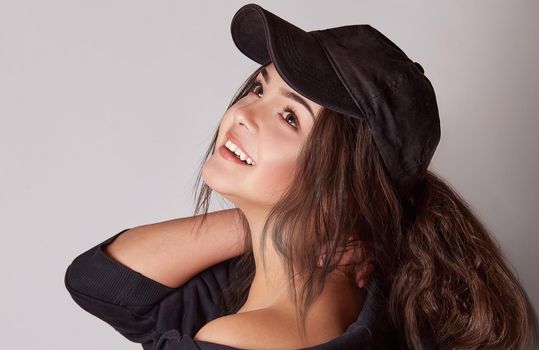 Very attractive young woman in a cap posing in studio