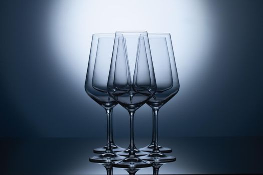 Empty wine glasses on a blue clean gradient background. Empty drinking transparent wine glasses