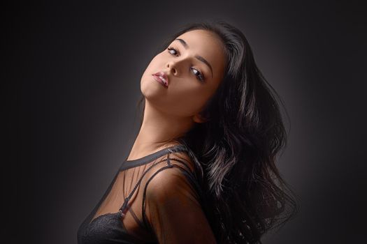 Portrait fashionable young woman in studio on black background