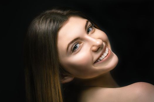 Portrait smiling young woman in studio on black background. Youth concept