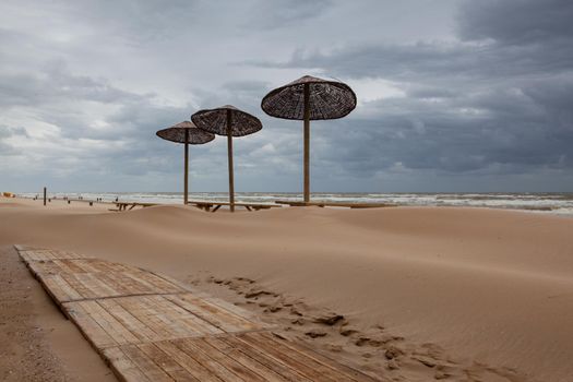 The sand-covered tables on the beach in Egmont aan Zee, Netherlands. The beach without foreign tourists after the coronavirus pandemic.