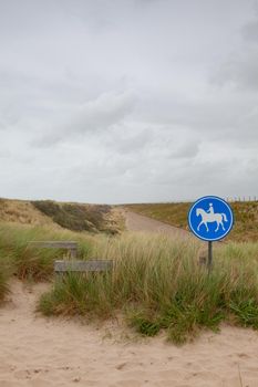 Blue road sign for riders on the beach in De Putten in Netherlands. The road without tourists after the coronavirus pandemic.
