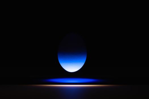 Blue egg levitating over a black glass table in the dark room.