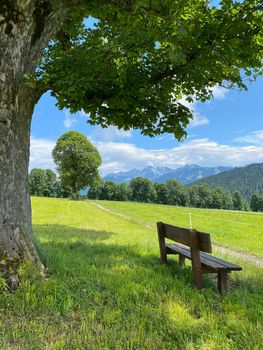 Landscape with bench in Ramsau am Dachstein, Austria. This wonderful area of alpine pastures at the foot of the imposing south wall of Dachstein offers many hiking and amazing lookout points.