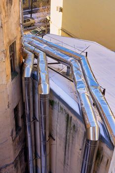 View of the boiler pipes laid on the wall and roof of the house. Close up