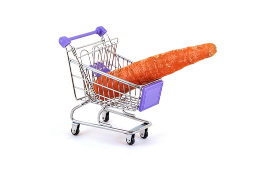 A ripe red carrot lies in a small supermarket trolley on a white background, close up