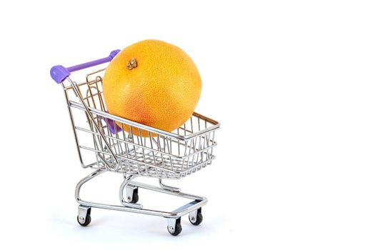 Orange orange lies in a small supermarket trolley on a white background, close-up