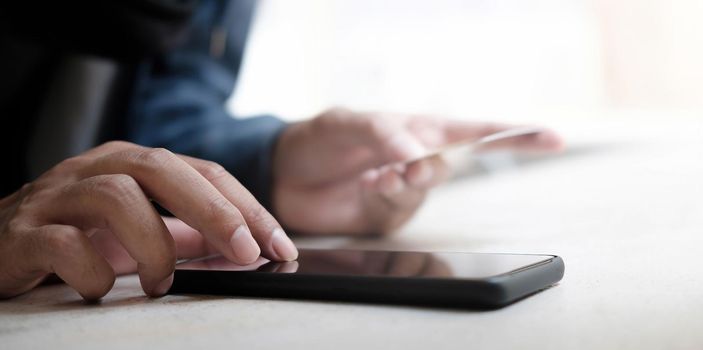 Online payment,Man's hands holding a credit card and using smart phone for online shopping.