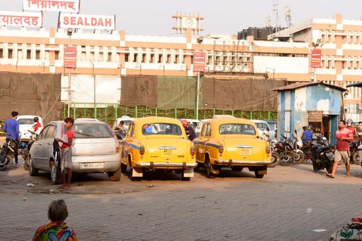 Kolkata's yellow Ambassador car cabs parked in the prepaid taxi booth outside Sealdah station platform main entrance gate. Sealdah Railway station Building Exterior, Kolkata, India, 8 March 2021