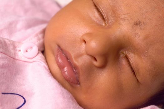 Extreme Close up face of a cute sleeping newborn baby. Closeup portrait of a Sweet One month old infant baby boy captured in sleepy mood. Front view. Child care kid background image.