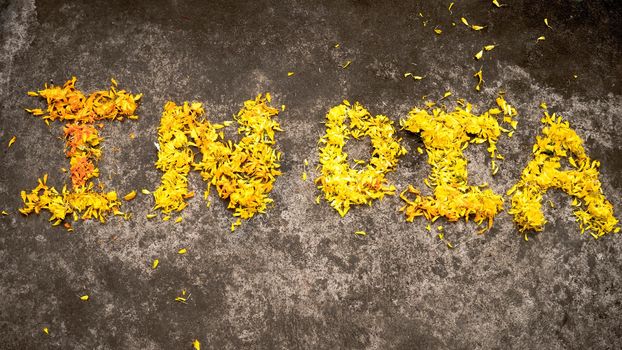 The Word India written with yellow marigold flowers in 26th January on India Republic day celebration. 15th August Independence Day Holiday background concept. High angle view. Close Up.