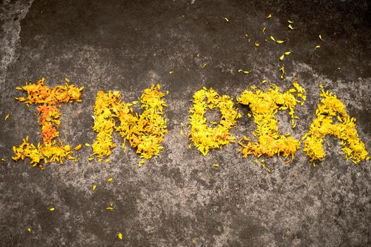 The Word India written with yellow marigold flowers in 26th January on India Republic day celebration. 15th August Independence Day Holiday background concept. High angle view. Close Up.