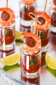 Appetizer of shish kebab with shrimps and chorizo sausages with barbecue sauce in a glass