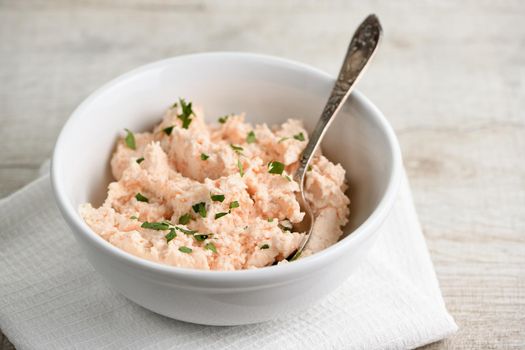 bowl of  pate  salmon with soft cheese and herb,  a textile napkin on a wooden table