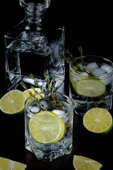 Cocktail with white rum and tonic, a slice of lime and thyme