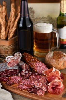 Antipasti dish with bacon, jerky, salami, crispy grissini with cheese. A meat appetizer is a great idea for a beer.