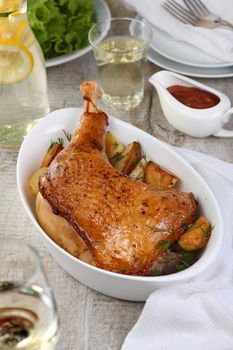 Roasted turkey leg with potatoes on the dinner table