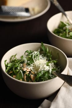 Arugula salad with sunflower kernels and sprinkled with grated parmesan
