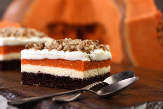 Pumpkin pie - light, creamy dessert with cheese cream and pumpkin layers topped with chopped nuts