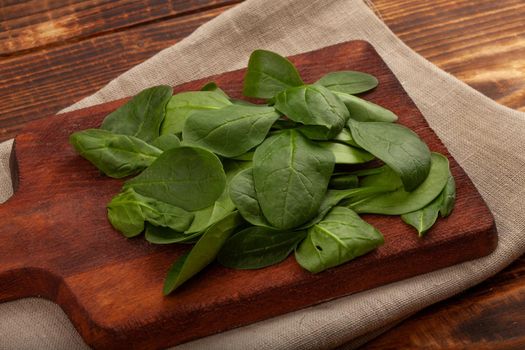 Heap of fresh green spinach on the wooden board