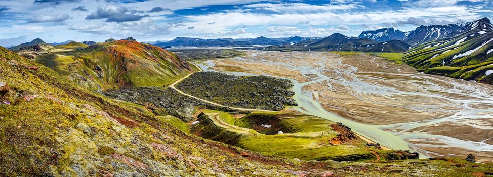 Panoramic landscape view of colorful rainbow volcanic Landmannalaugar mountains, volcanoes, lava fields, crater, water streams and floods at blue sky with clouds, Iceland, summer