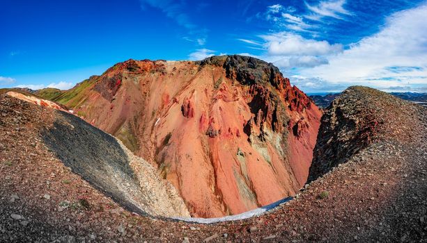 Panoramic true Icelandic landscape view of colorful rainbow volcanic Landmannalaugar mountains, red and pinky volcanic crater and famous Laugavegur hiking trail at blue sky, Iceland