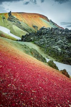 Colorful rainbow volcanic Landmannalaugar mountains at famous Laugavegur hiking trail, with dramatic sky view and snow in Iceland, summer