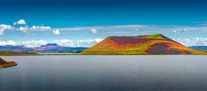 Panoramic view of colorful pseudo craters and volcanoes near Skutustadir town at lake Myvatn in Iceland, blue sky with clouds