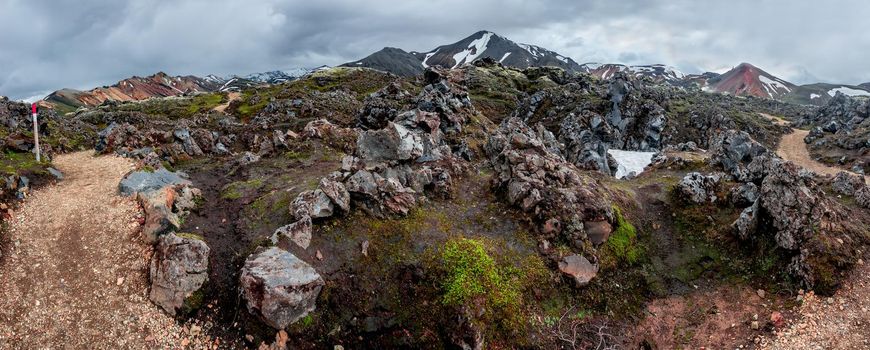 Panoramic landscape view of colorful rainbow volcanic Landmannalaugar mountains and hiking trail path at dramatic sky in Iceland, summer