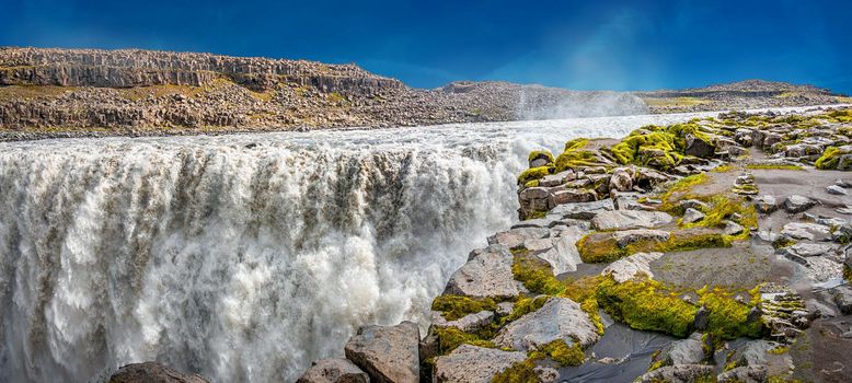 Panoramic view over biggest and most powerful waterfall in Europe called Dettifoss in Iceland, near lake Myvatn, at blue sky