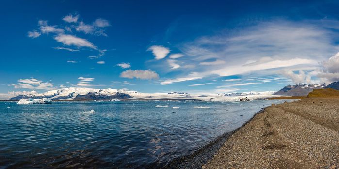 Panoramic view of Glacier Lagoon Jokulsarlon with icebergs and Vatnajokull Glacier tongue, Iceland