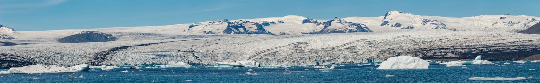 Panoramic view of Glacier Lagoon Jokulsarlon with icebergs and Vatnajokull Glacier tongue, Iceland