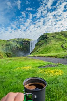 Making morning coffee in front of famous Skogarfoss waterfall, while hiking in Iceland