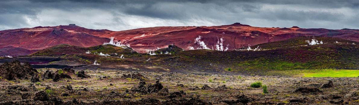 Panoramic view over colorful and smoky rhyolite volcanic mountains in Icelandic Highlands near lake Myvatn, summer, scenic dramatic itinerary