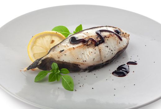 Roasted catfish steak with basil, lemon and balsamic sauce on the plate