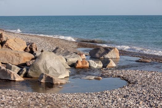 Landscape with small mountain river flows into the sea