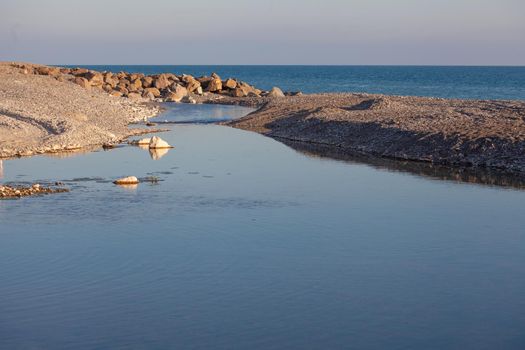 Landscape with small mountain river flows into the sea