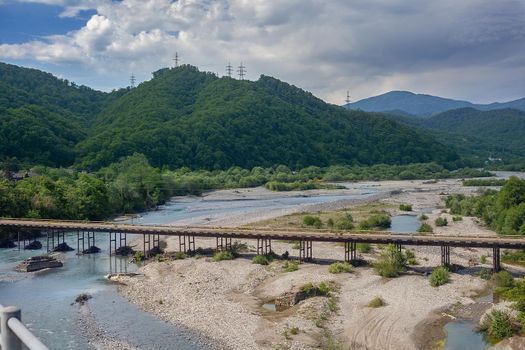 Old road bridge over mountain river Shakhe