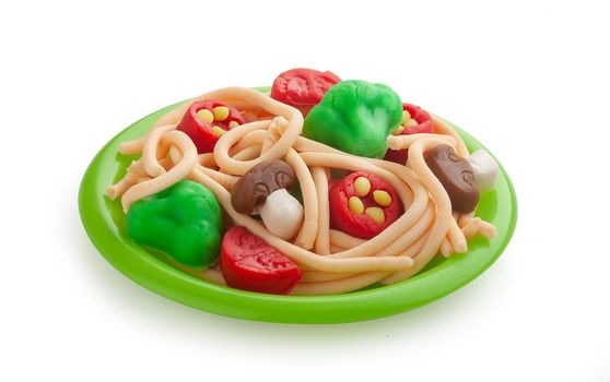 Isolated plasticine pasta with vegetables on the plastic plate