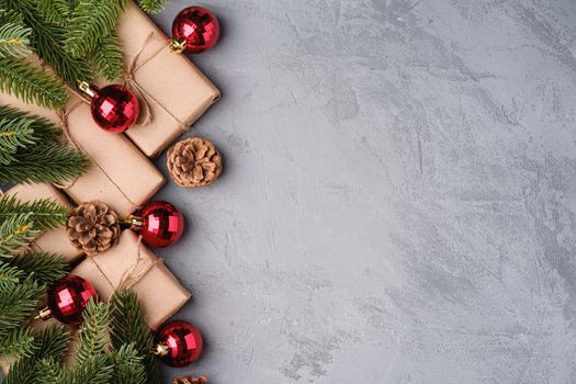 Christmas holidays composition. Red ornament and bauble decorations, fir-tree, gifts and pine cones. Copy space